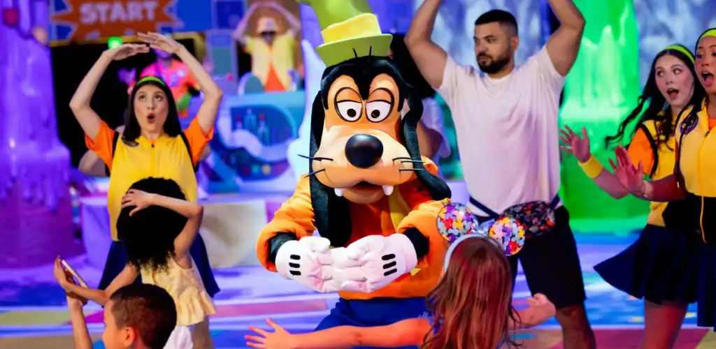 Goofy dancing with guests at the colorful GoofyCore party