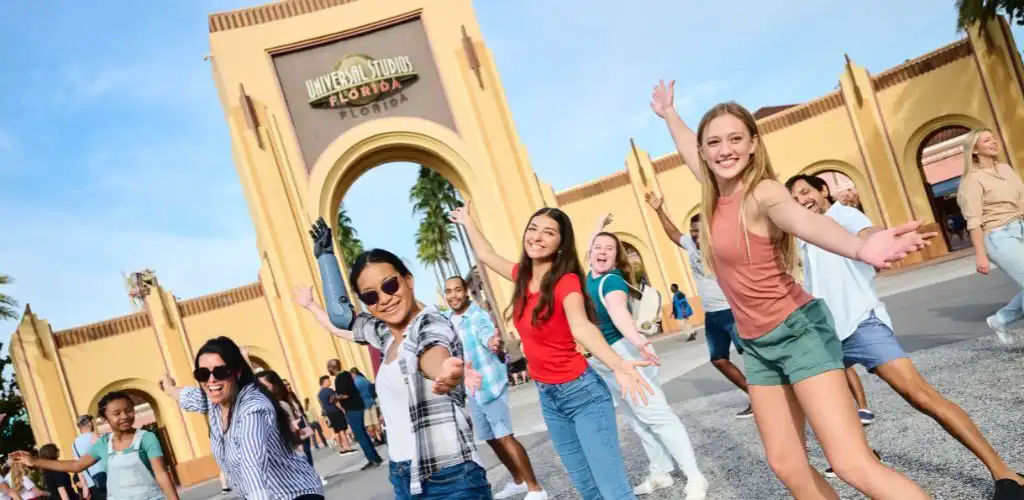 Excited group of friends posing in front of the Universal Studios Florida entrance, ready for a day of thrilling rides and unforgettable adventures at Universal Orlando Resort.