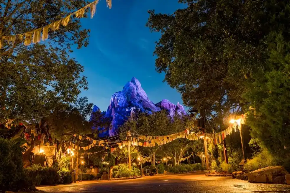 Expedition Everest glowing at night in Disney's Animal Kingdom, with prayer flags and lanterns adding to the immersive Himalayan atmosphere