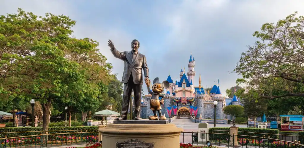 Statue of Walt Disney and Mickey Mouse in front of Sleeping Beauty Castle at Disneyland park during daytime