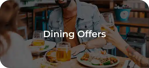 A group of people enjoying a meal together at a restaurant table with drinks and food, sharing a lively dining experience.