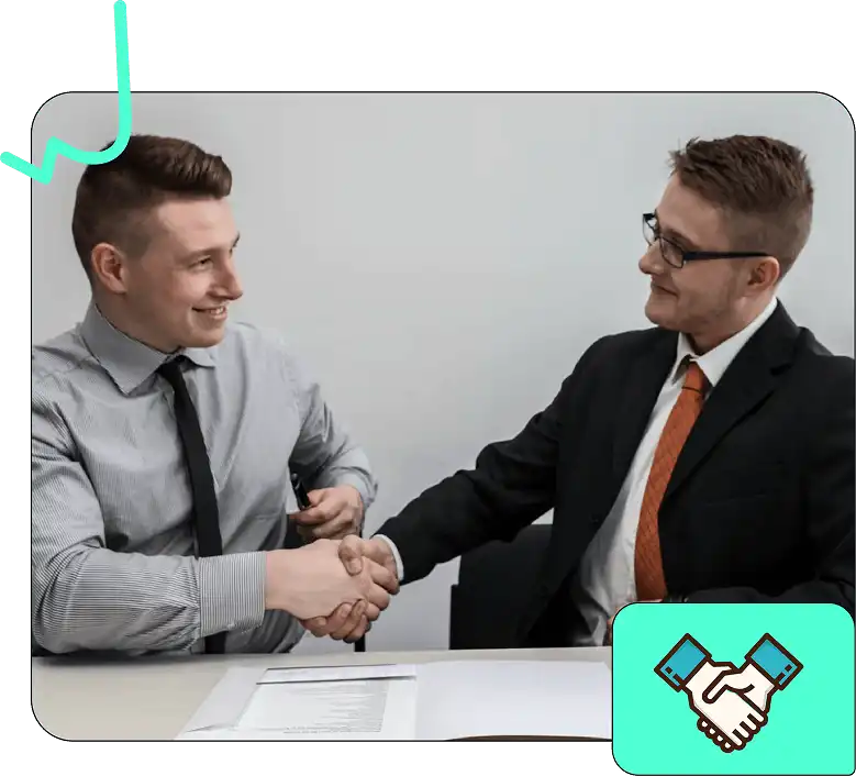 Two men in business attire are shaking hands during a meeting, symbolizing agreement or partnership, with a document on the table.