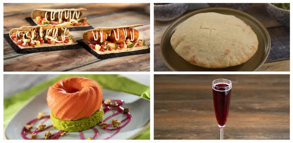 Assorted food items including tacos, flatbread, a dessert with a green base and pink topping, and a glass of red wine on a wooden surface.