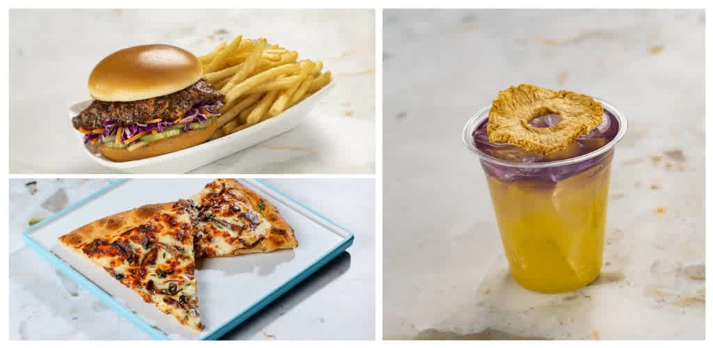 A burger with fries, a slice of pizza, and a pineapple upside-down drink with a pineapple slice garnish.