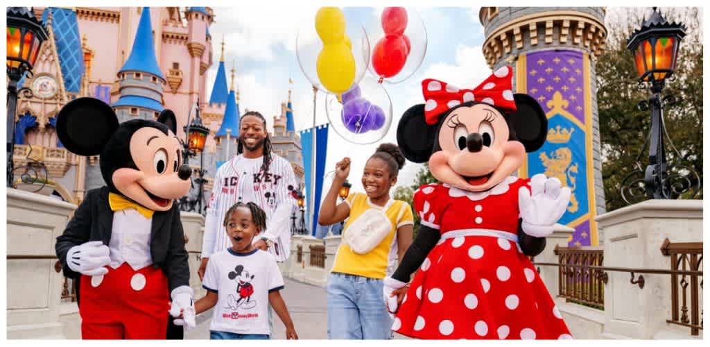 People with Mickey and Minnie Mouse costumes enjoying a family day at Disneyland with children and balloons in the background