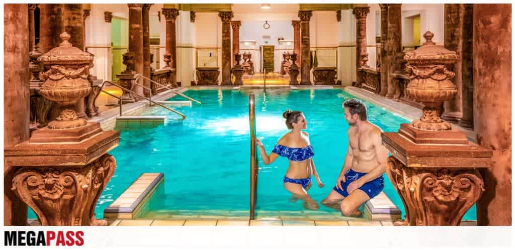 Indoor swimming pool with ornate wooden columns, a couple in swimsuits enjoying the water, and warm lighting creating a luxurious relaxing atmosphere