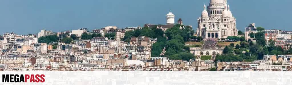 View of the Sacré-Cœur Basilica on a hill overlooking a city with many buildings and greenery in the background