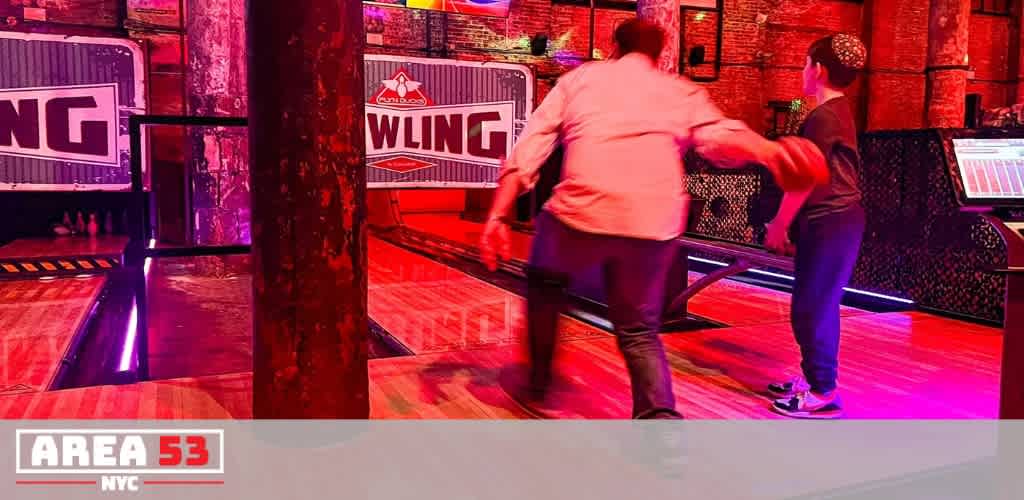 Two people playing a game in a dimly lit arcade with colorful lights and wooden floors at funex com