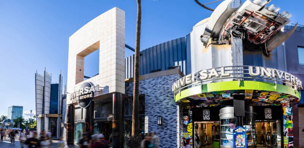 Universal Studios store entrance with colorful signage and a crowd of visitors on a bright day outside the themed retail location.