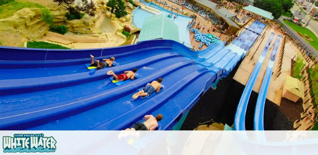 Children sliding down blue water slides at White Water amusement park during daytime