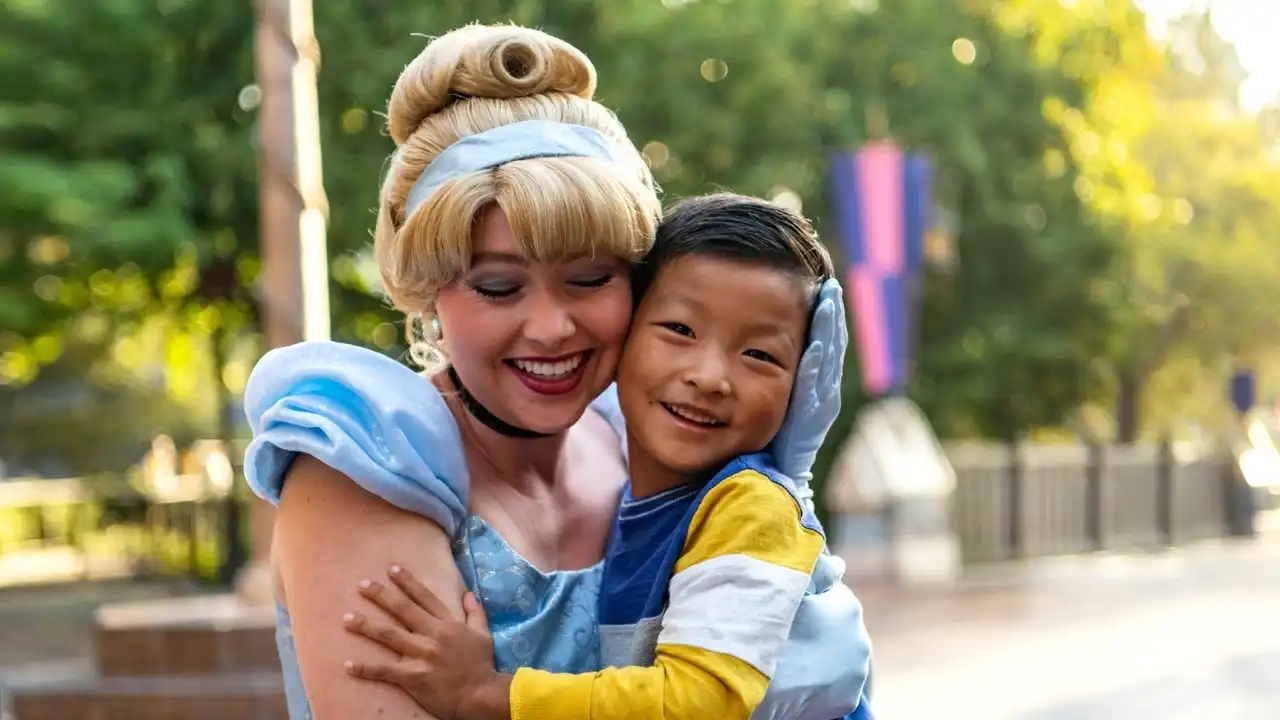 Cinderella hugging a young boy during a character meet-and-greet at Disneyland Resort