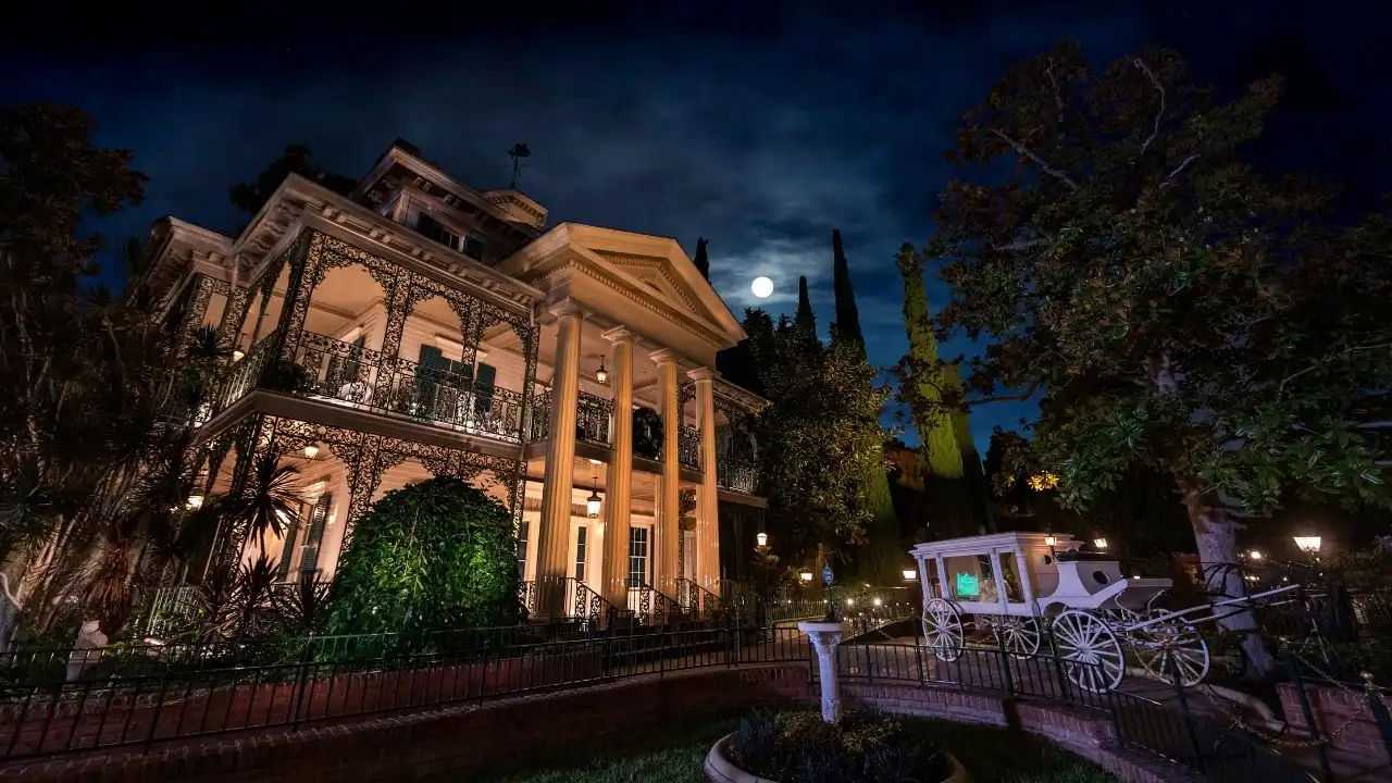 Haunted Mansion exterior with hearse at night at Disneyland Resort