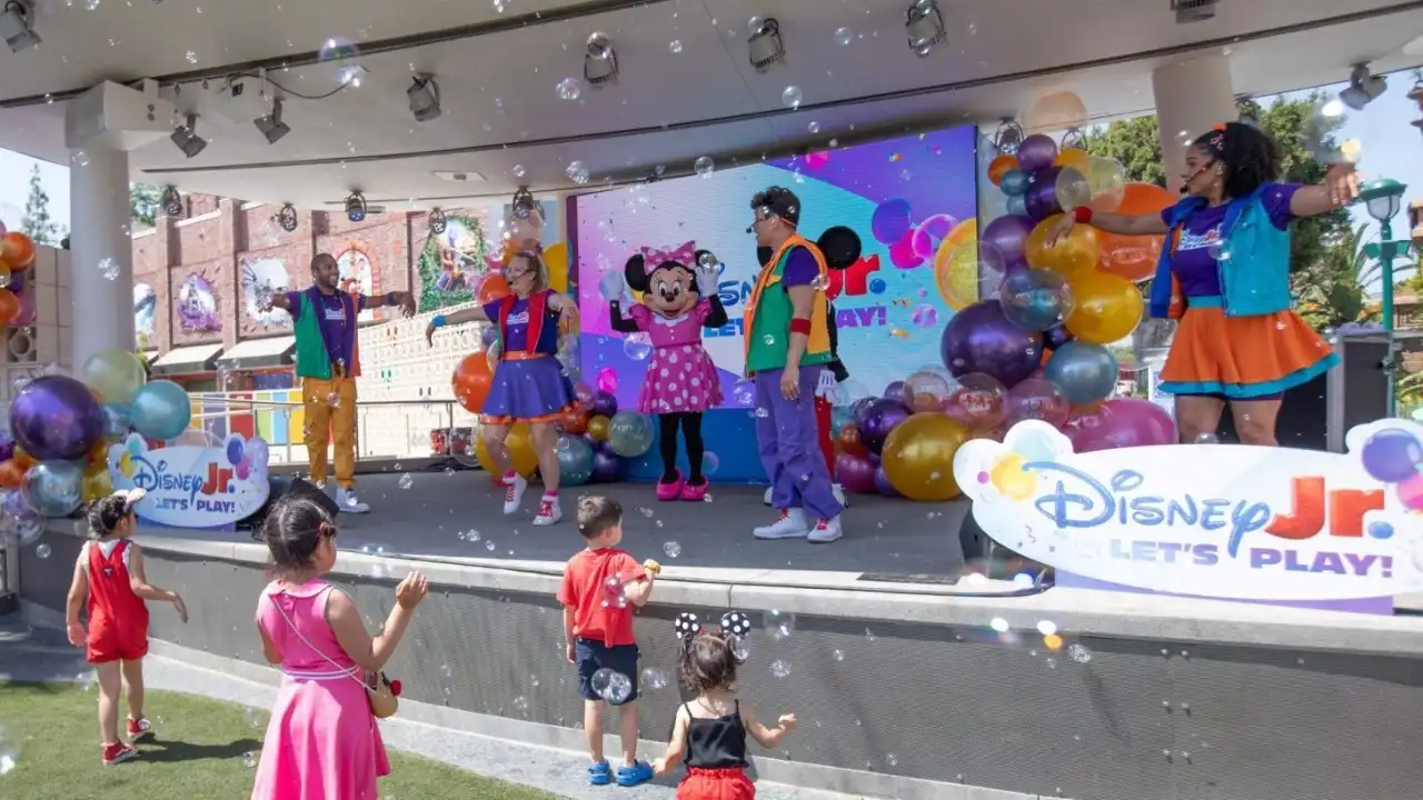 Mickey Mouse waving with balloons at Disney Jr. Let's Play event