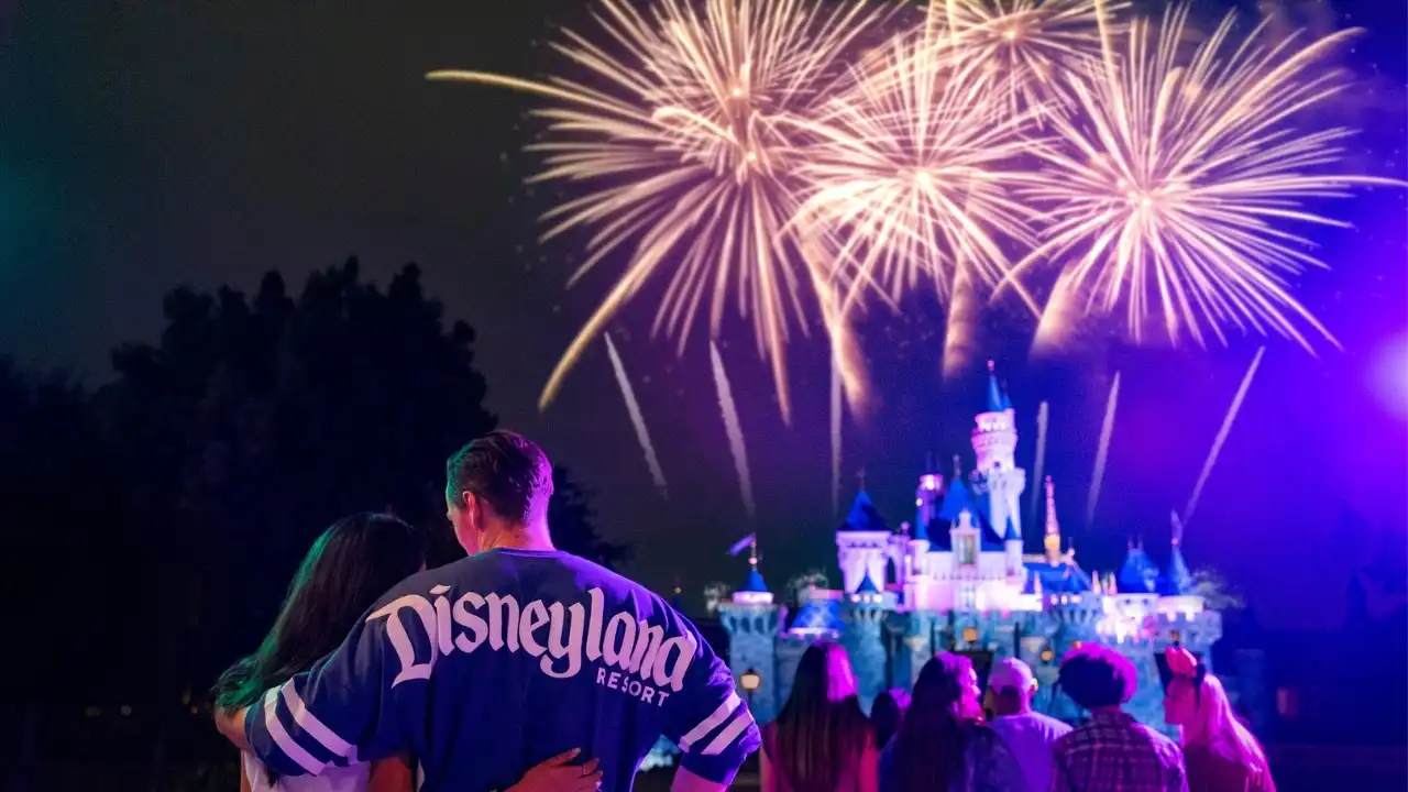 Couple in Disneyland Resort jacket watching castle fireworks at Disneyland
