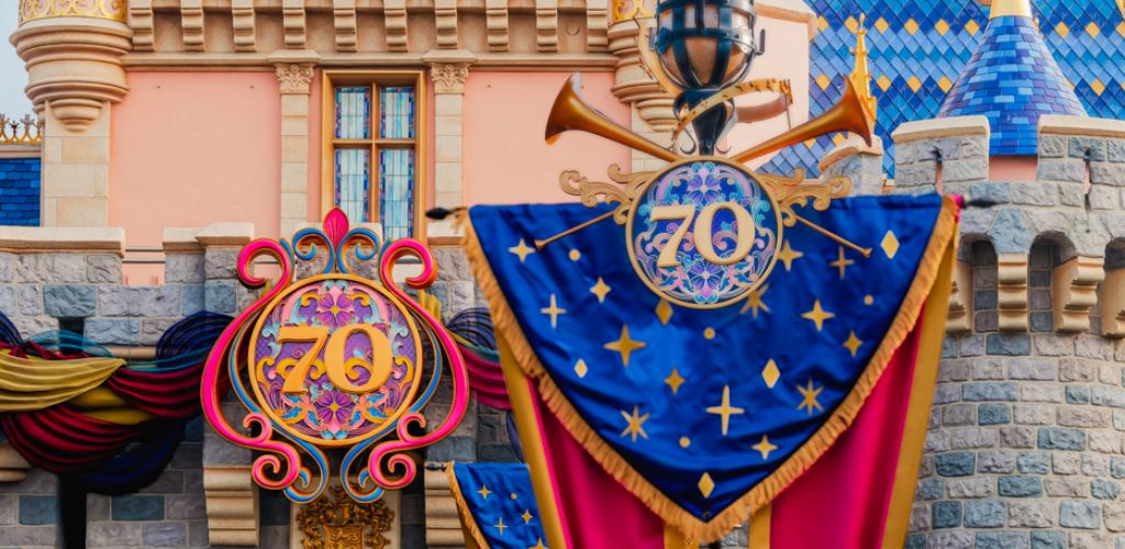 Castle with colorful decorations celebrating a 70th anniversary, featuring a large blue banner with gold stars and a decorative emblem displaying the number seventy.